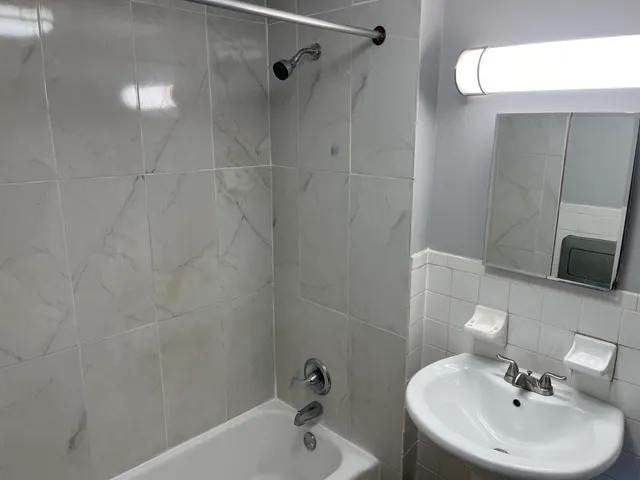 a bathroom with a sink a mirror and shower