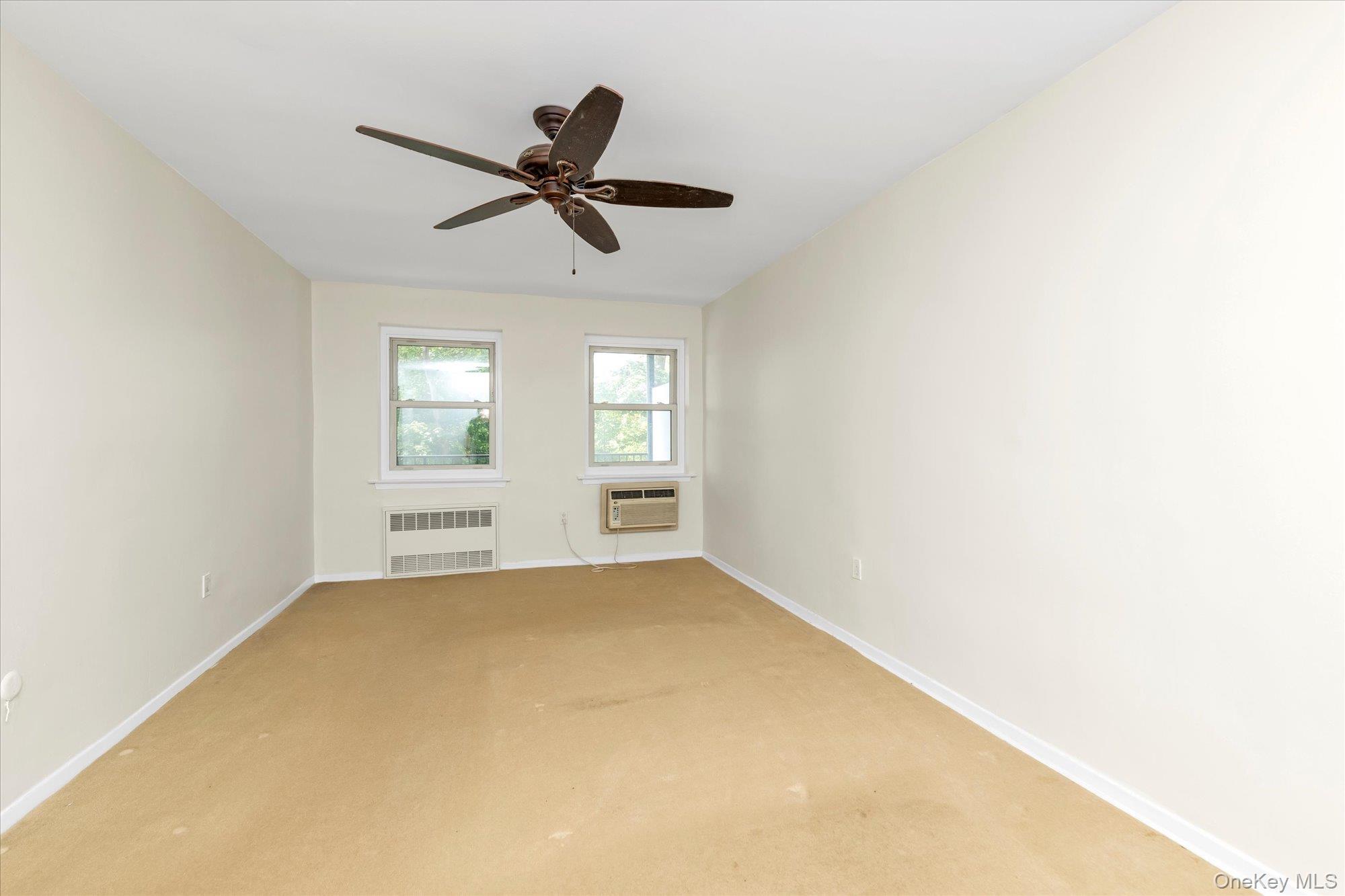 30 Pearsall Avenue, Unit 2F Glen Cove, NY 11542 - Photo 14 of 25 Carpeted bedroom with wood floors underneath and ceiling fan