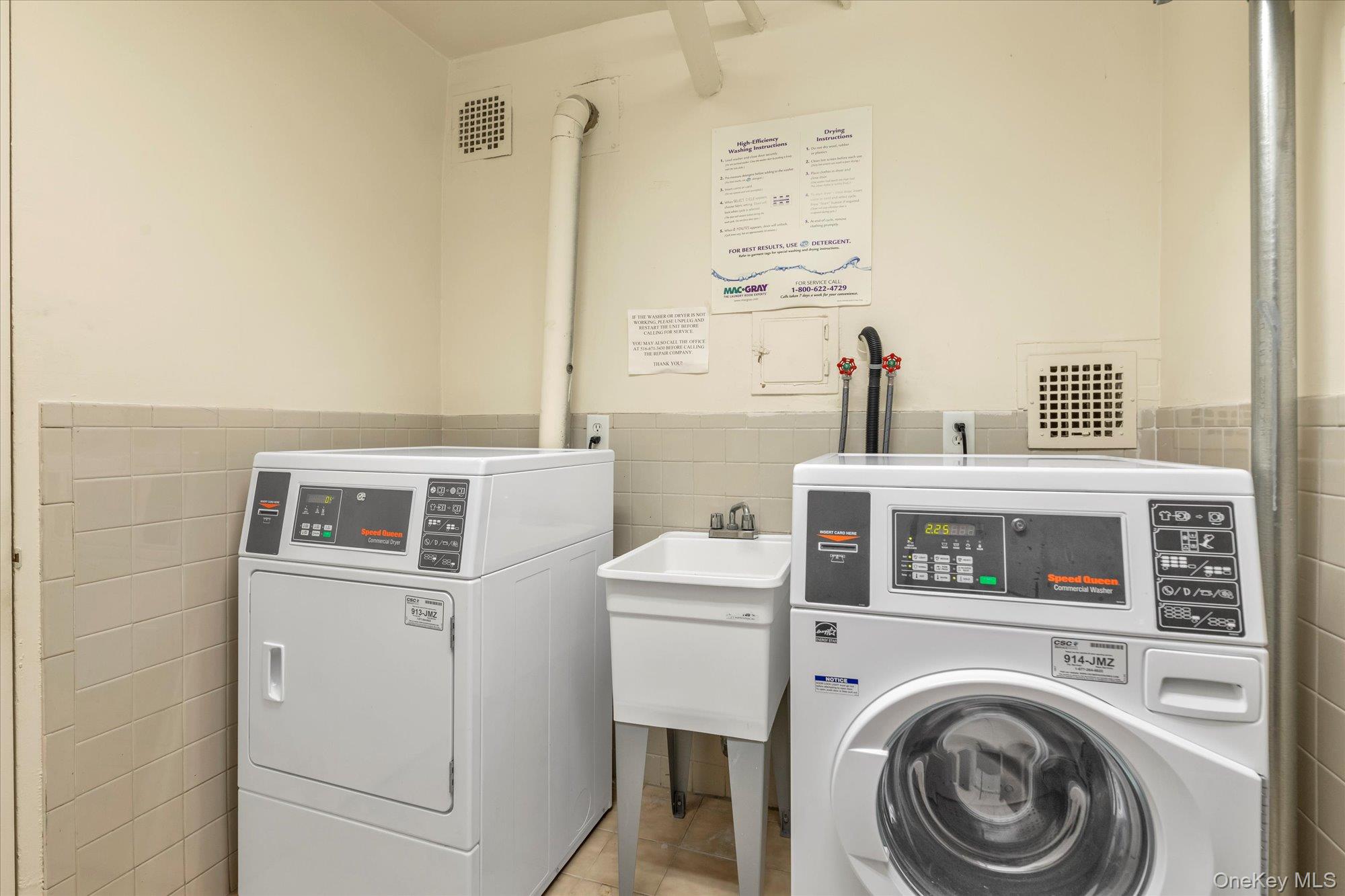 30 Pearsall Avenue, Unit 2F Glen Cove, NY 11542 - Photo 21 of 25 Community laundry featuring tile walls, a wainscoted wall, light tile patterned flooring, and independent washer and dryer