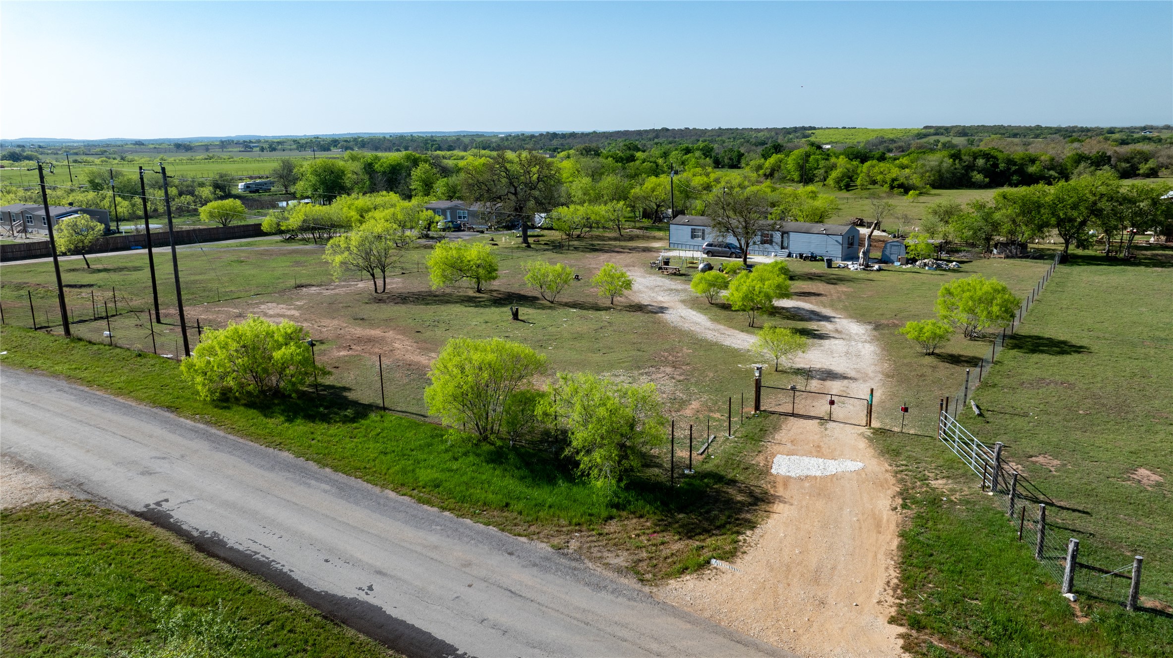 6575 Taylorsville Road Dale, TX 78616 - Photo 4 of 15 A sprawling rural property awaits, featuring mature trees and a fenced perimeter.