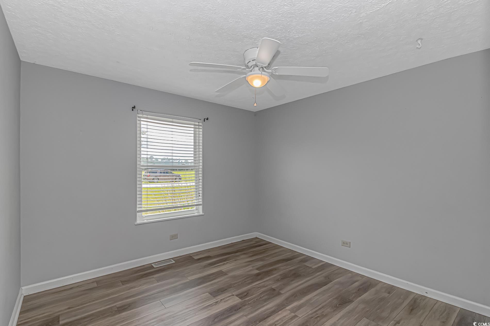 2829 Highway 129 Galivants Ferry, SC 29544 - Photo 11 of 40 Empty room with dark wood-type flooring, a textured ceiling, and a ceiling fan