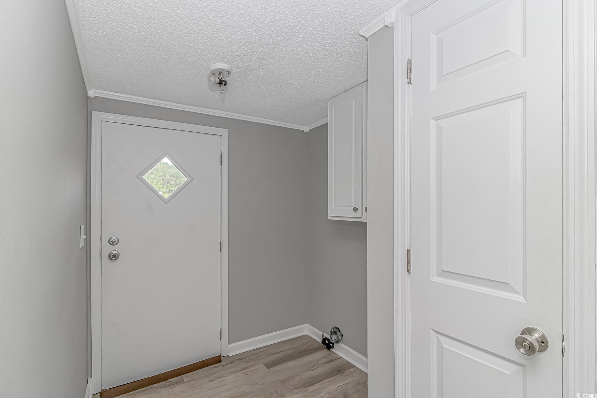 2829 Highway 129 Galivants Ferry, SC 29544 - Photo 30 of 40 Laundry area with light wood-style floors, a textured ceiling, and crown molding