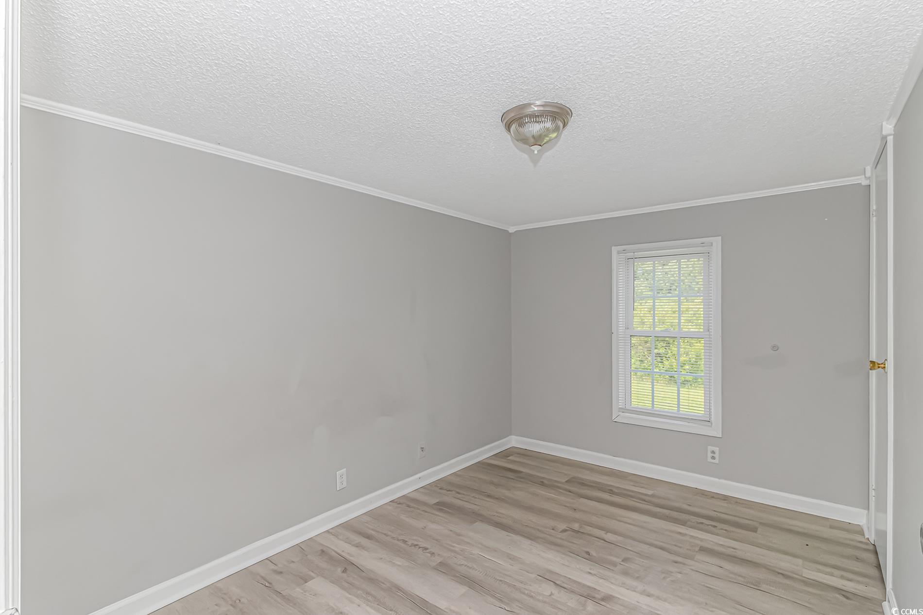 2829 Highway 129 Galivants Ferry, SC 29544 - Photo 31 of 40 Unfurnished room featuring light wood-style floors, a textured ceiling, and ornamental molding