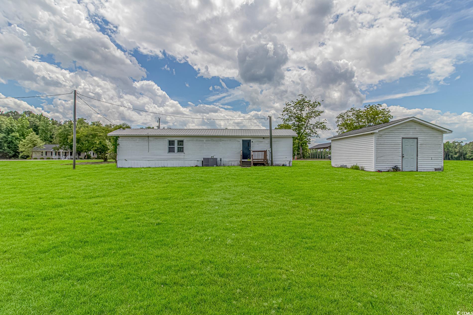2829 Highway 129 Galivants Ferry, SC 29544 - Photo 34 of 40 Rear view of property featuring a lawn, a metal roof, and an outbuilding