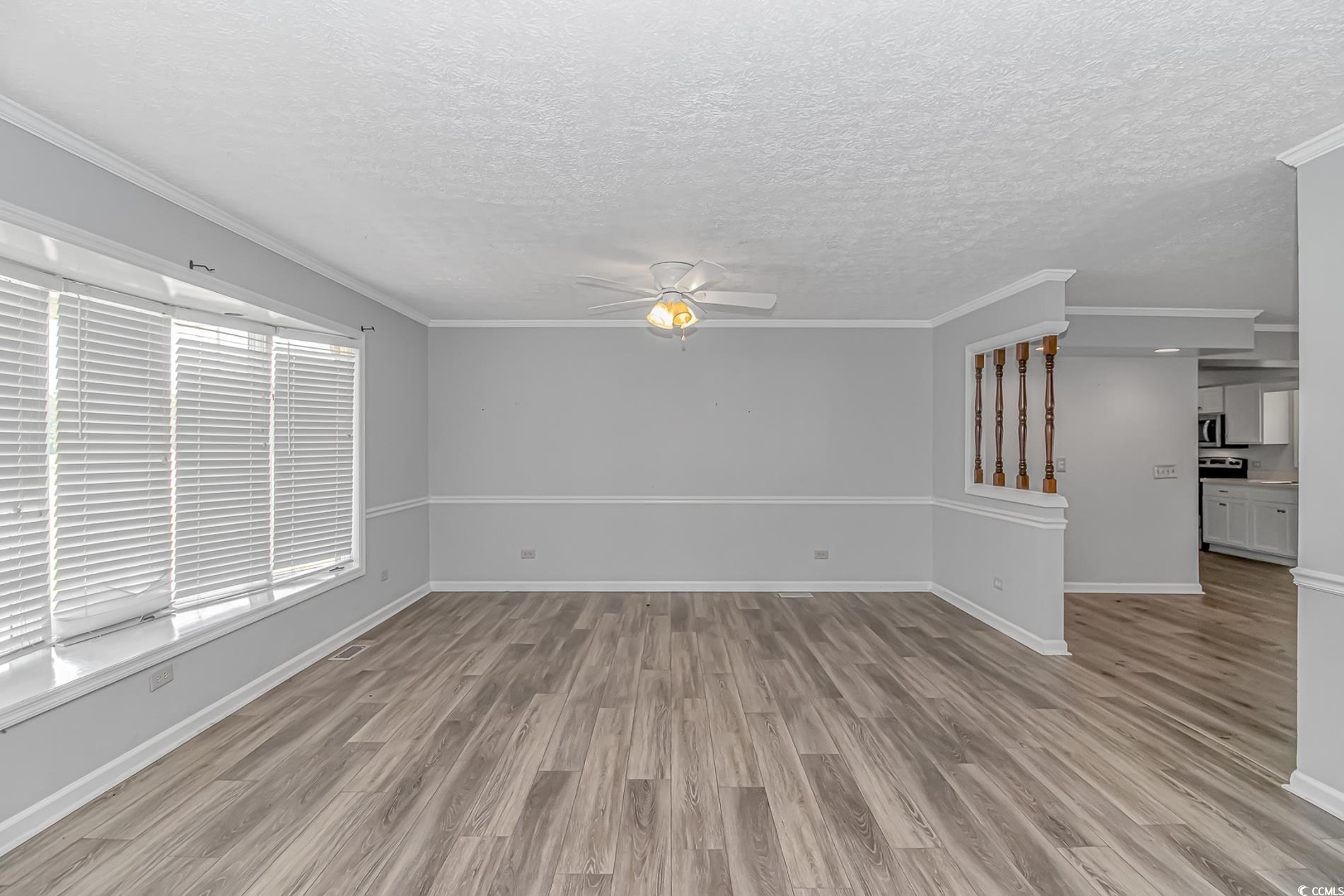 2829 Highway 129 Galivants Ferry, SC 29544 - Photo 4 of 40 Empty room featuring ceiling fan, light wood-style flooring, a textured ceiling, and ornamental molding