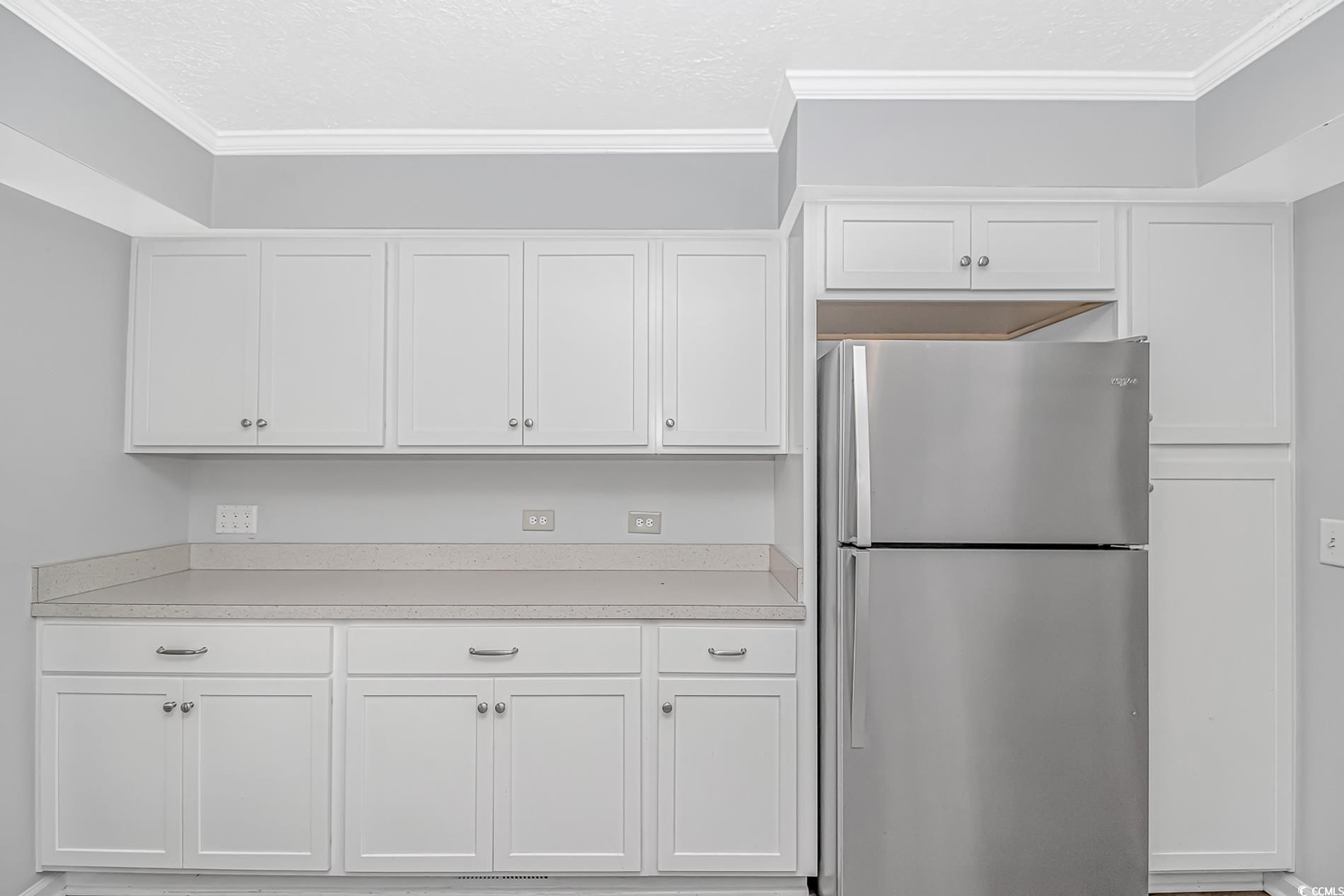 2829 Highway 129 Galivants Ferry, SC 29544 - Photo 8 of 40 Kitchen with freestanding refrigerator, white cabinetry, light countertops, and ornamental molding