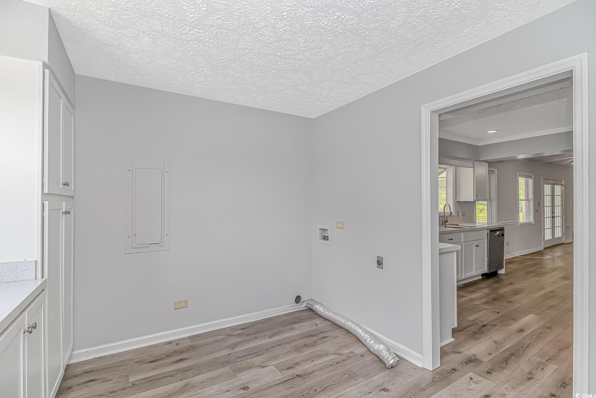 2829 Highway 129 Galivants Ferry, SC 29544 - Photo 10 of 40 Laundry room with electric dryer hookup, washer hookup, light wood-style floors, electric panel, and cabinet space