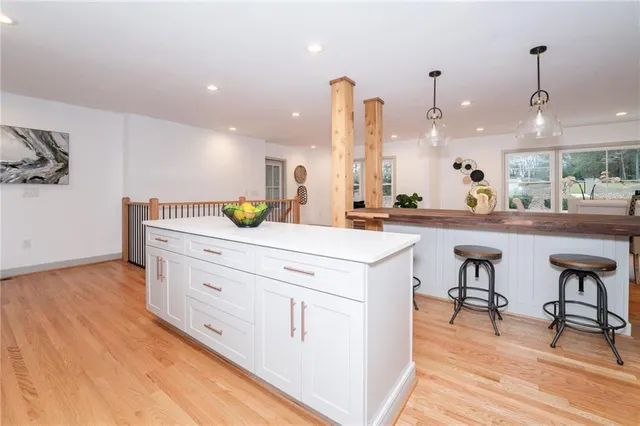 a kitchen with a sink a counter space and a view of living room
