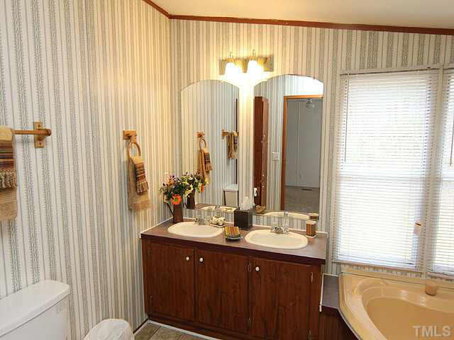 4501 Durham Road Raleigh, NC 27614 - Photo 8 of 12 a bathroom with a double vanity sink and a mirror