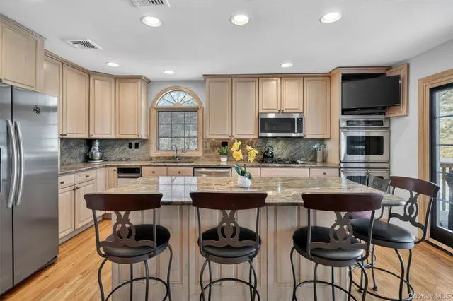 a kitchen with stainless steel appliances a stove a sink and a refrigerator