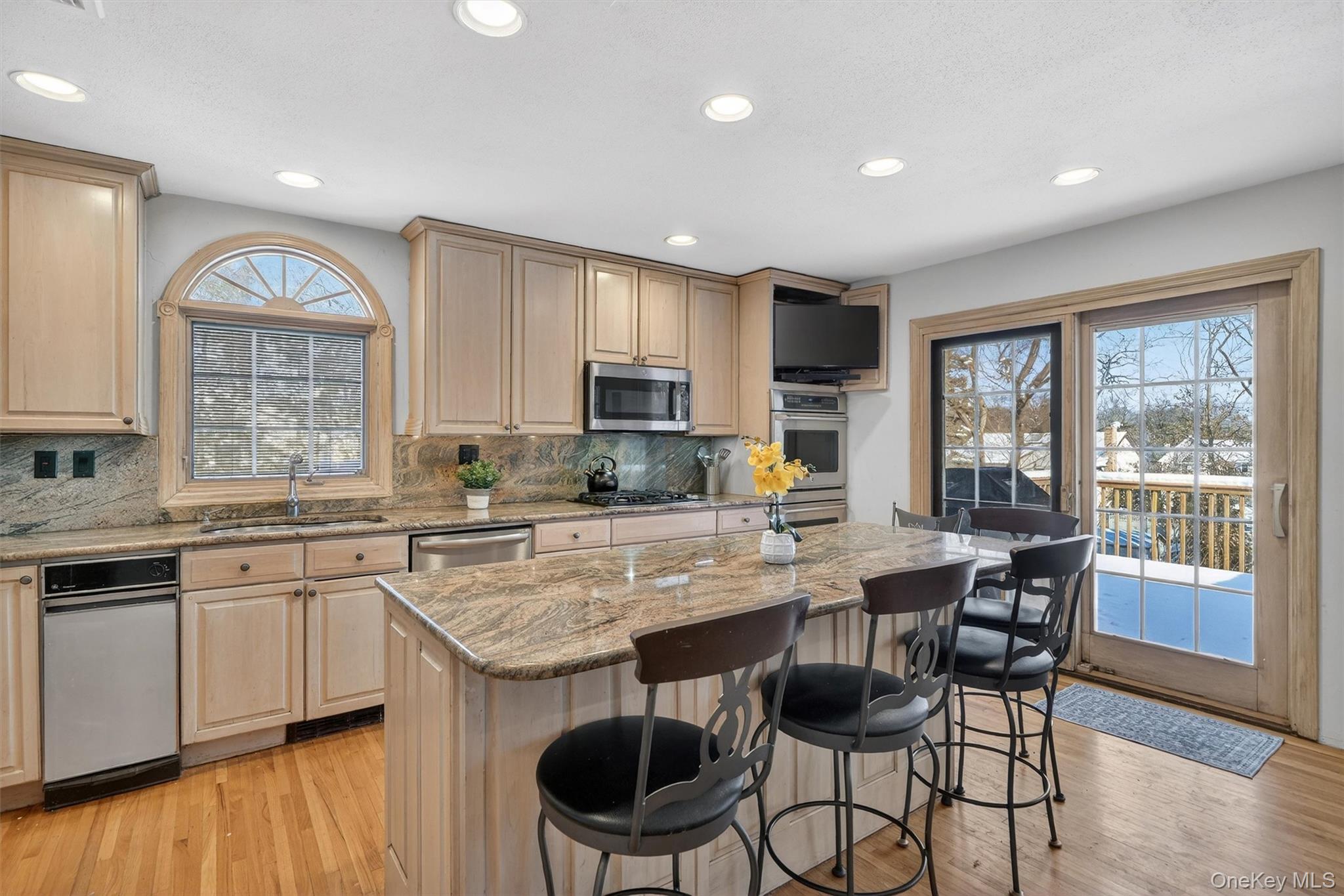 5 Raleigh Drive New City, NY 10956 - Photo 8 of 44 a kitchen with stainless steel appliances granite countertop a stove top oven a sink dishwasher a dining table and chairs with wooden floor