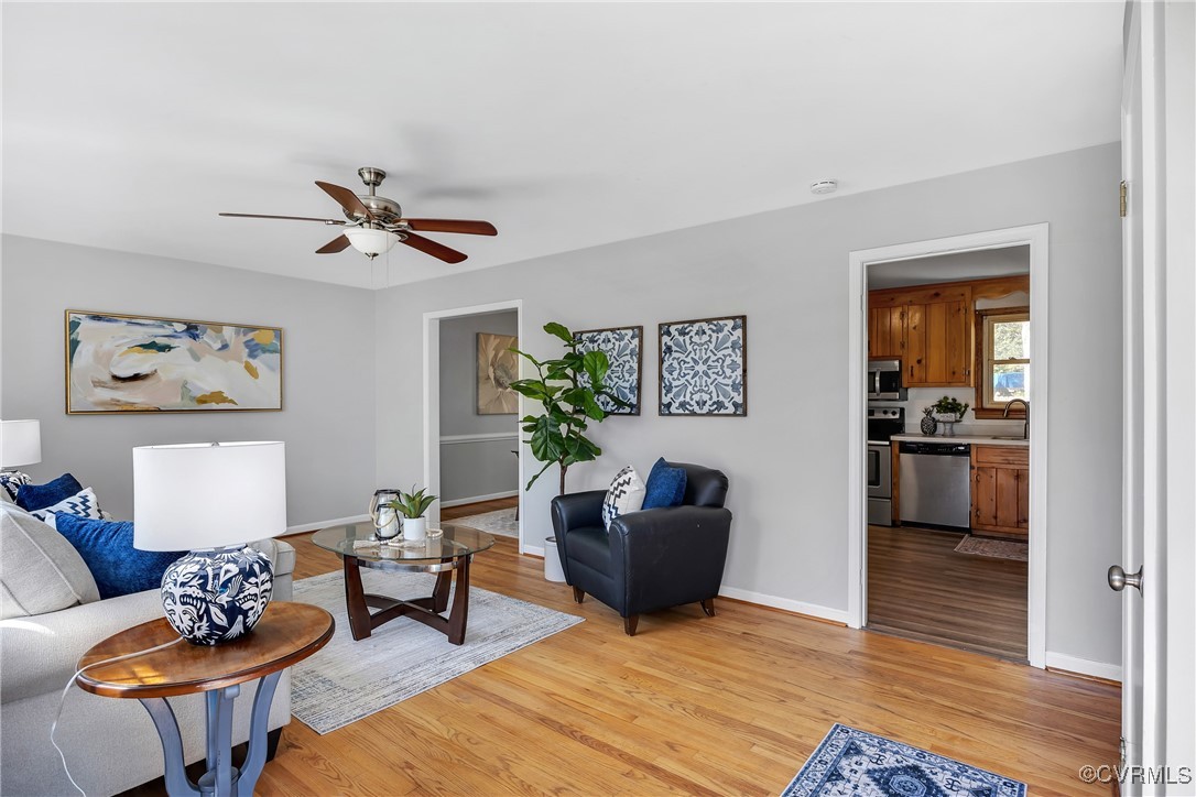 Living area with baseboards, light wood finished f