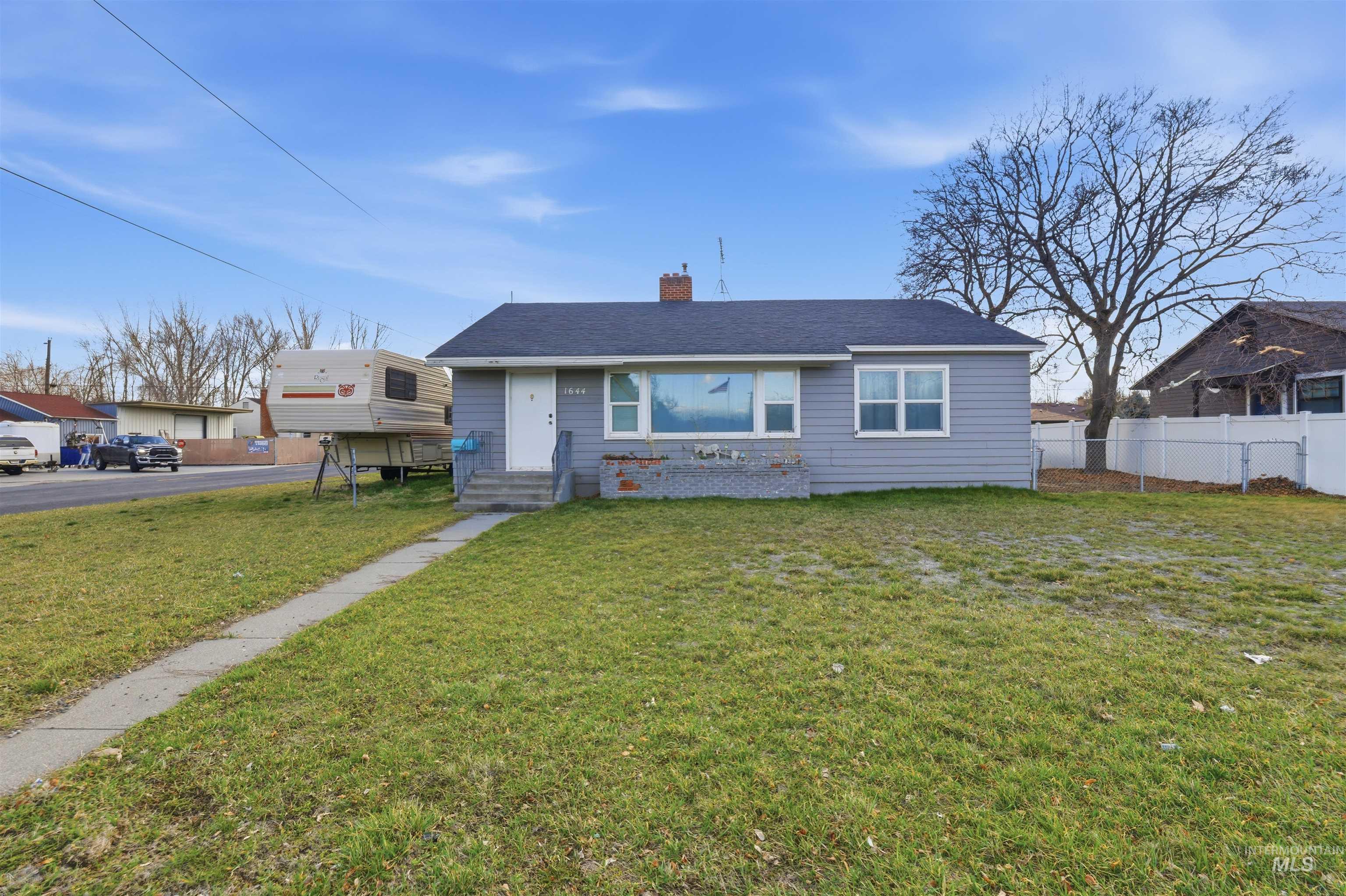 View of front of property featuring a chimney and roof with shingles
