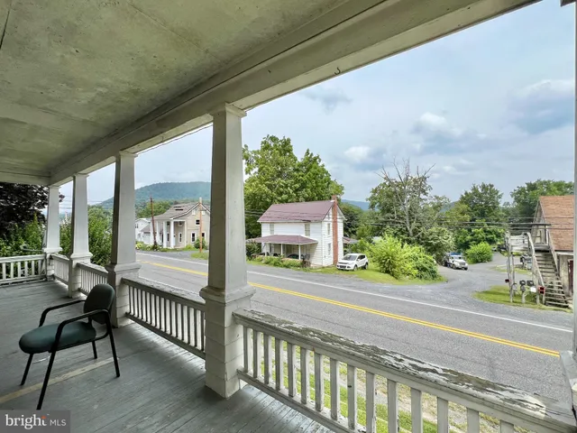 a view of a porch with furniture and a yard