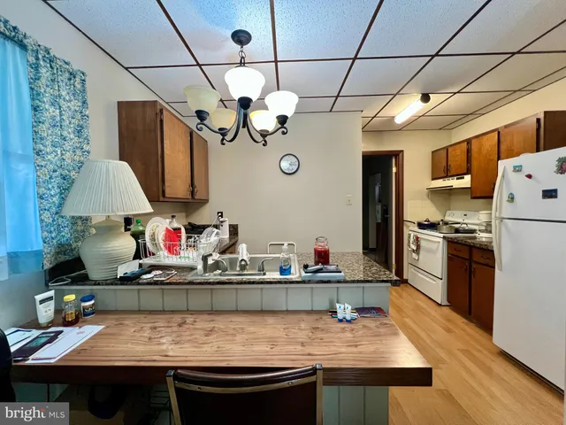 a kitchen that has a lot of cabinets and stainless steel appliances
