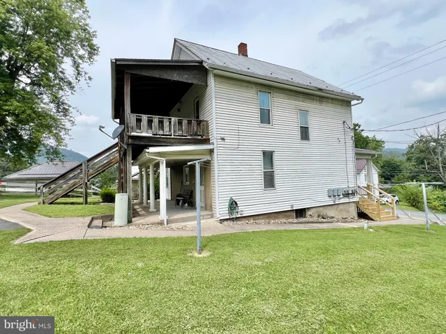 a view of a house with a yard and sitting area