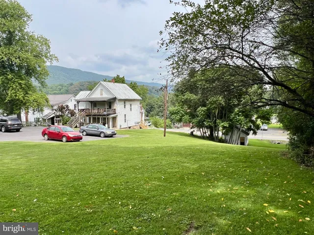 a view of a house with a yard and sitting area