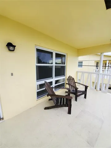 a view of a big house with a big yard and large trees