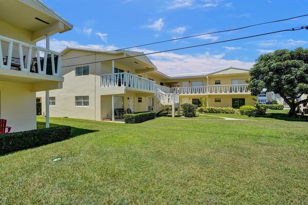 2755 Northeast 28th Avenue, Unit E3 Lighthouse Point, FL 33064 - Photo 16 of 48 a view of a big house with a big yard and large trees