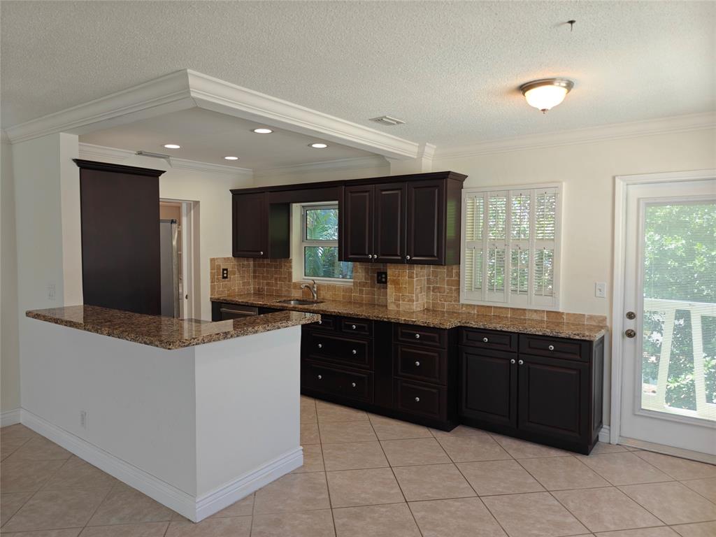 2755 Northeast 28th Avenue, Unit E3 Lighthouse Point, FL 33064 - Photo 24 of 48 a large kitchen with stainless steel appliances granite countertop a large counter top and a stove top oven
