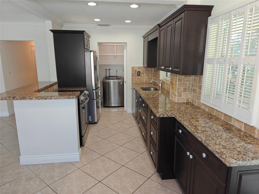 2755 Northeast 28th Avenue, Unit E3 Lighthouse Point, FL 33064 - Photo 25 of 48 a kitchen with stainless steel appliances granite countertop a stove a refrigerator a sink and dishwasher