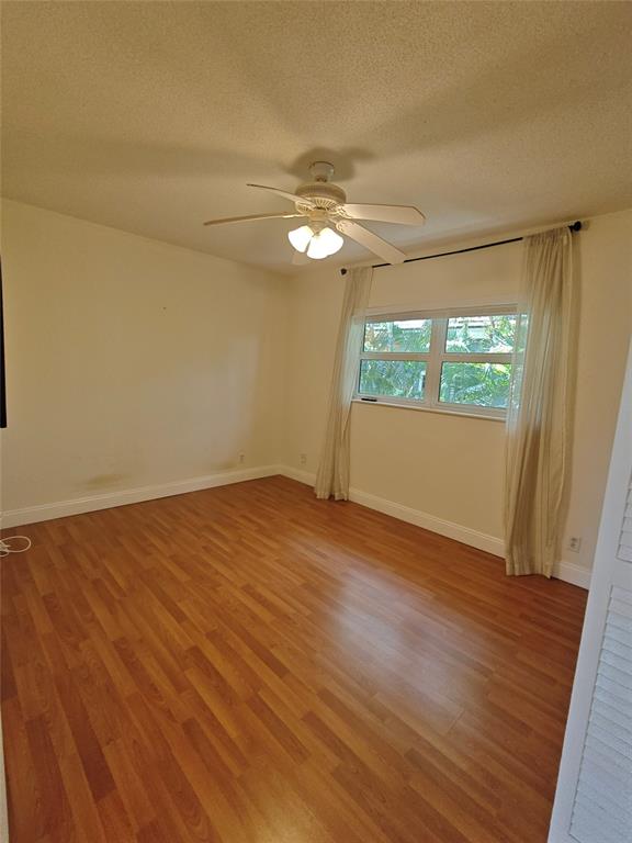 2755 Northeast 28th Avenue, Unit E3 Lighthouse Point, FL 33064 - Photo 37 of 48 an empty room with wooden floor fan and windows