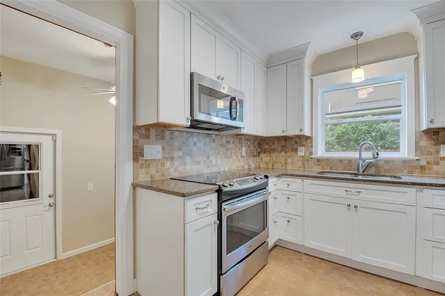 a kitchen with stainless steel appliances granite countertop a refrigerator and a stove top oven