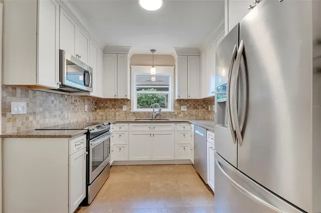 a kitchen with granite countertop white cabinets and a sink