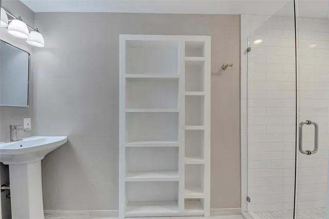 a view of a bathroom with a glass door shower and a sink