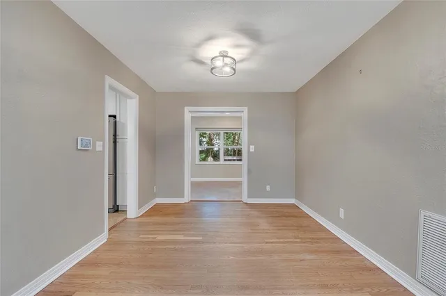 an empty room with mirror and a window