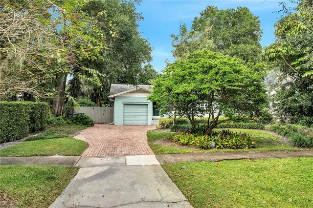 a front view of a house with a yard and trees