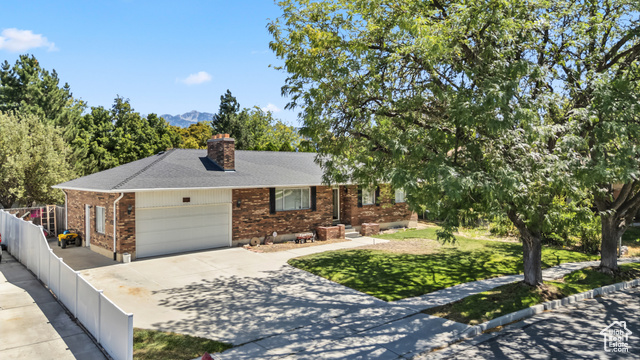 8843 Capernaum Road West Jordan, UT 84088 - Photo 26 of 31 Ranch-style home featuring brick siding, driveway, a chimney, an attached garage, and roof with shingles