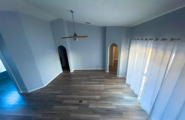a view of an empty room with wooden floor & closet