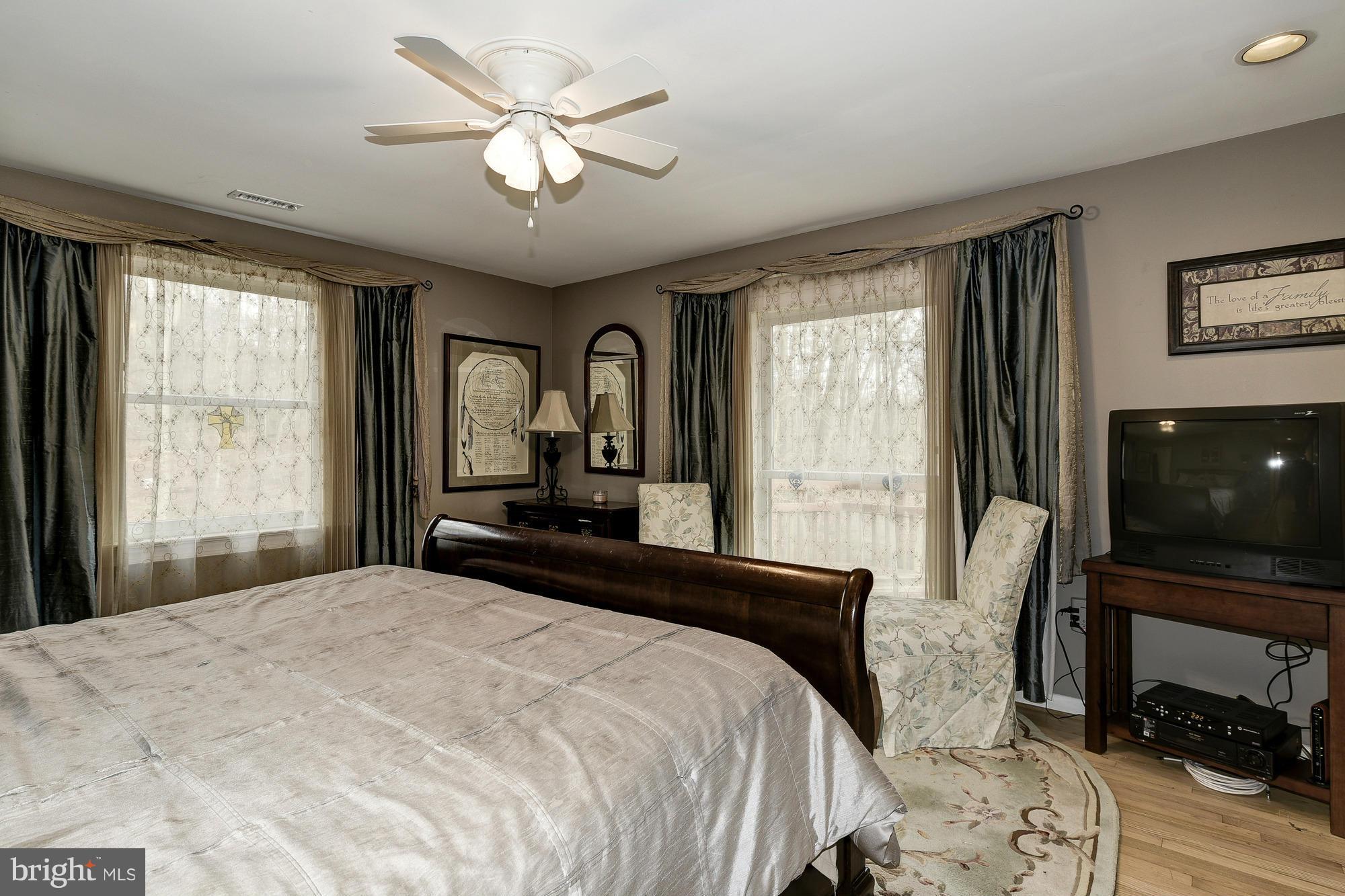 10302 Lloyd Road Potomac, MD 20854 - Photo 15 of 30 a bedroom with a bed a window and a flat screen television