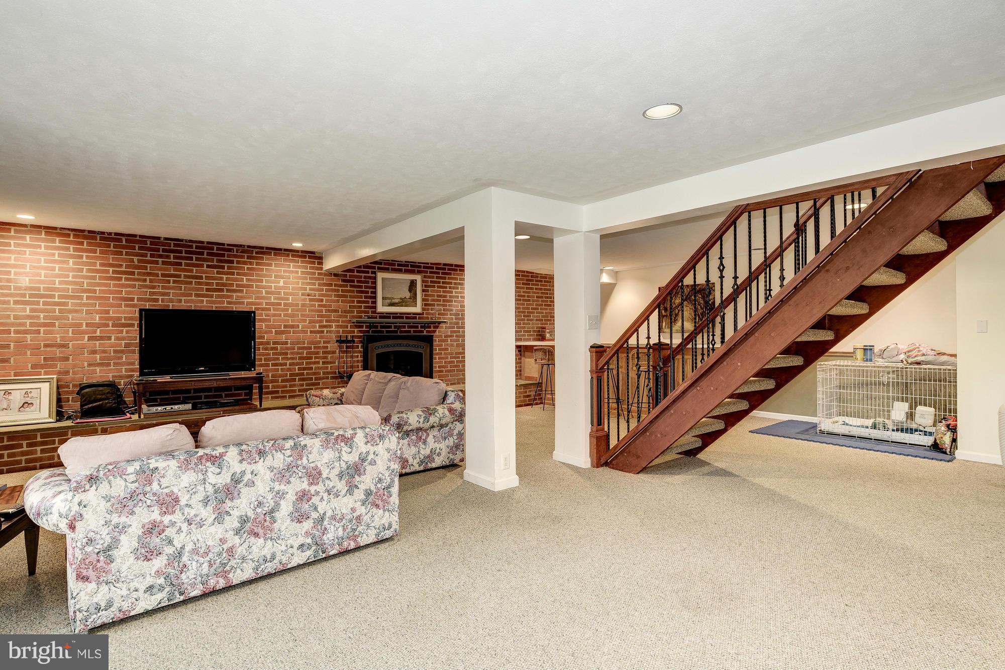 10302 Lloyd Road Potomac, MD 20854 - Photo 21 of 30 a view of livingroom with furniture flat screen tv staircase and a flat screen tv
