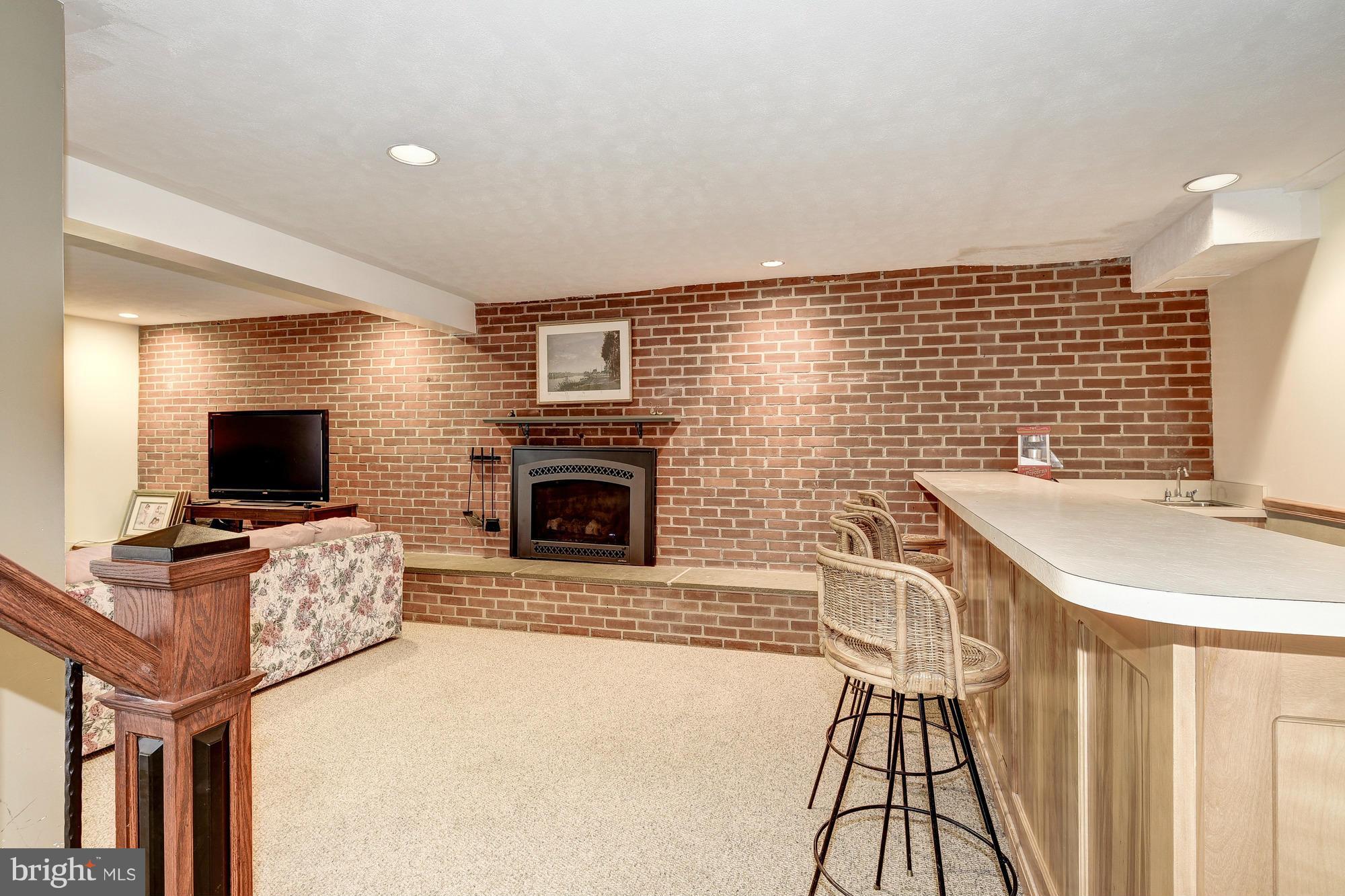 10302 Lloyd Road Potomac, MD 20854 - Photo 22 of 30 a living room with furniture a flat screen tv and a fireplace