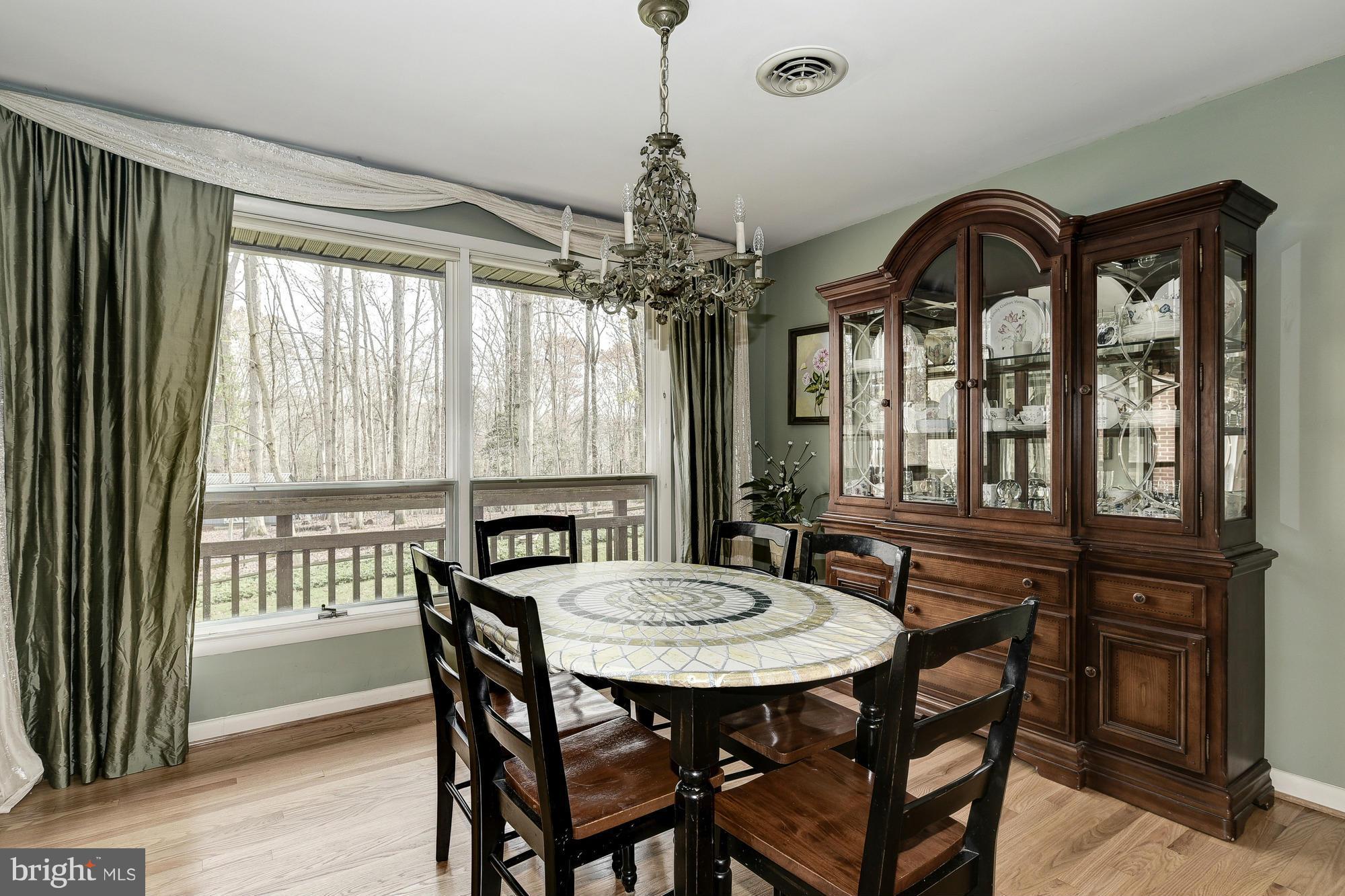 10302 Lloyd Road Potomac, MD 20854 - Photo 8 of 30 a view of a dining room with furniture window and wooden floor