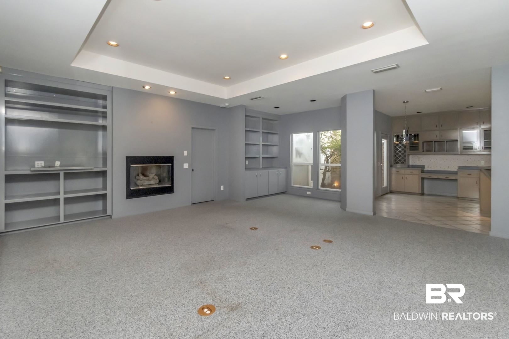 1205 Hillcrest Crossing East Mobile, AL 36695 - Photo 13 of 40 Unfurnished living room featuring built in features, carpet floors, and a tray ceiling