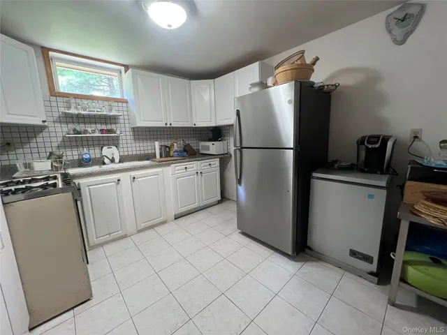 a kitchen with a refrigerator sink and cabinets