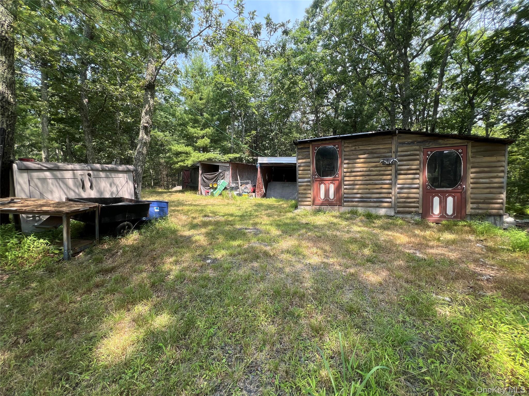 125 Woods Road Barryville, NY 12719 - Photo 22 of 25 a backyard of a house with table and chairs