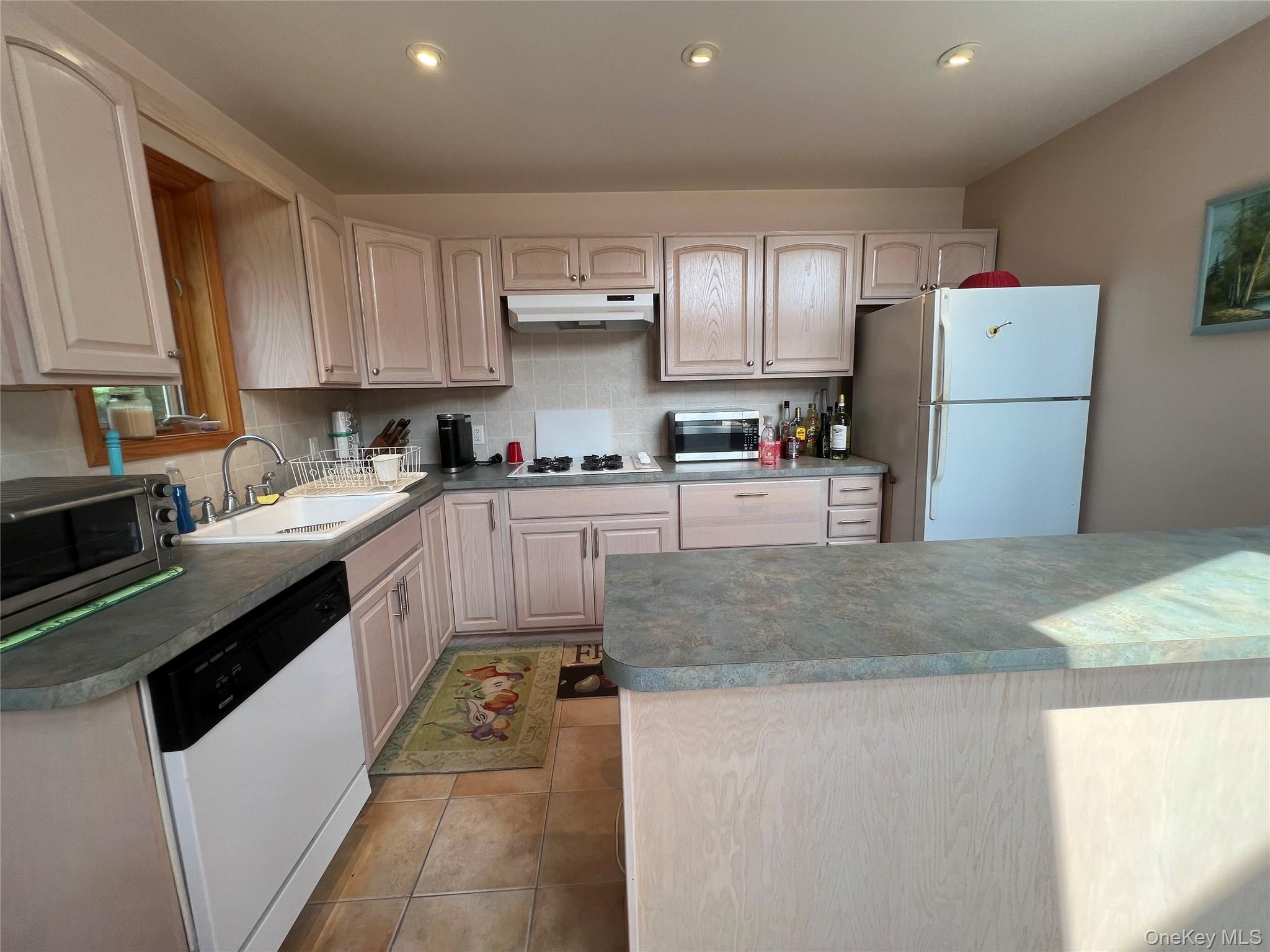 125 Woods Road Barryville, NY 12719 - Photo 3 of 25 a kitchen with a sink a stove a refrigerator and cabinets