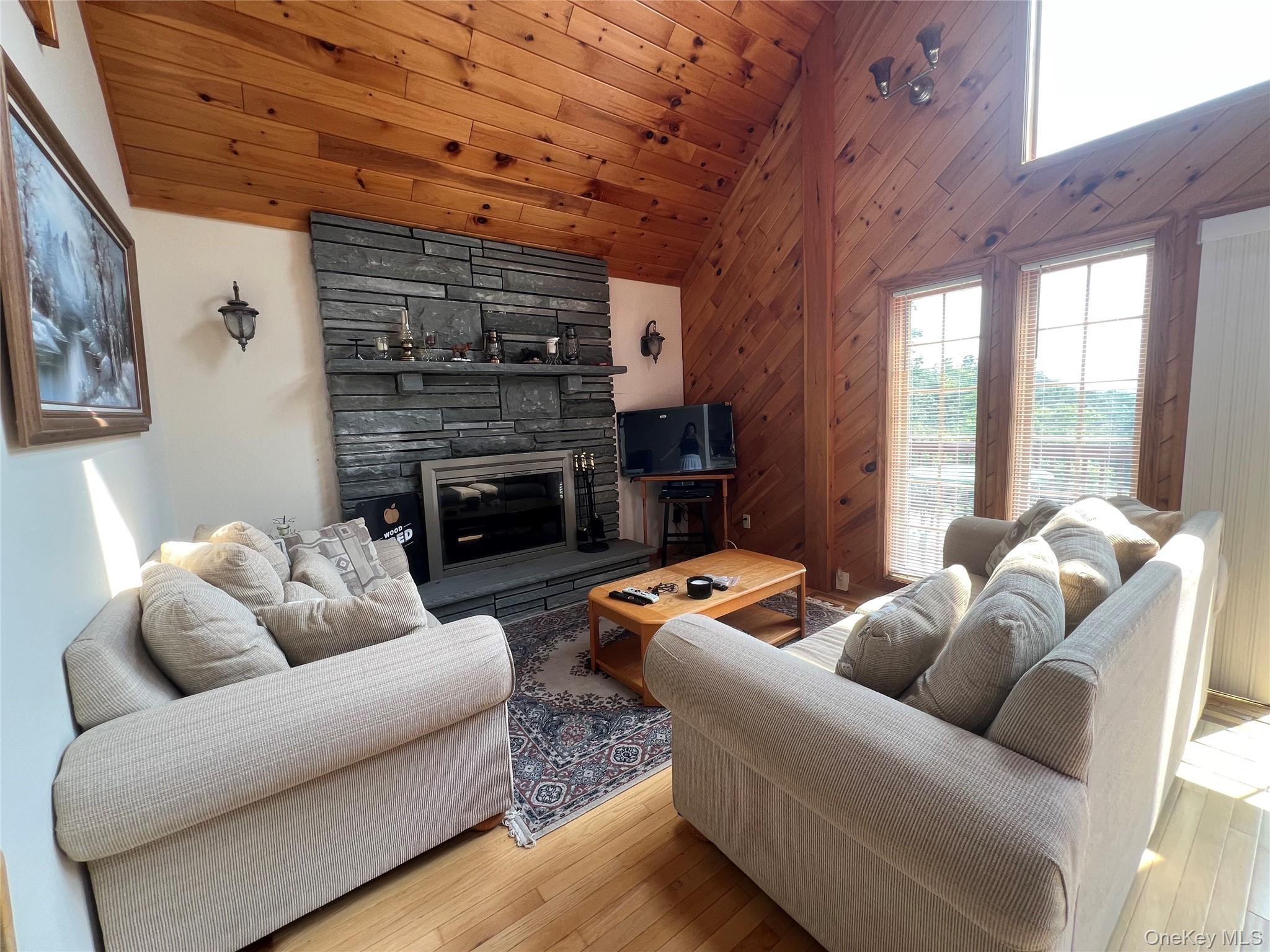 125 Woods Road Barryville, NY 12719 - Photo 6 of 25 a living room with furniture a fireplace and a table