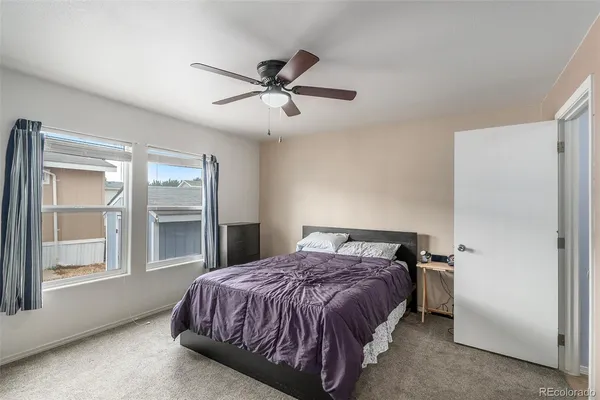 a bedroom with a bed and a flat tv screen on dresser