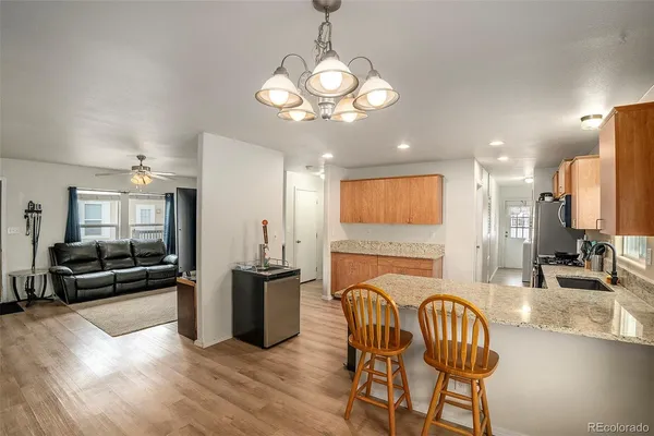 a view of a dining room with furniture a chandelier and wooden floor