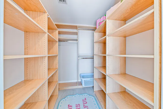 a view of walk in closet with empty racks