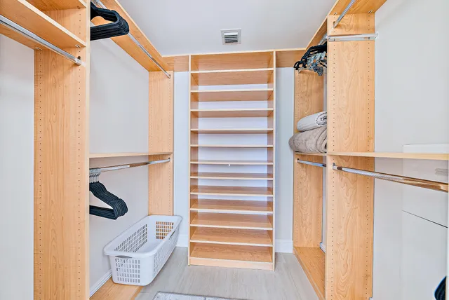 a view of walk in closet with empty racks