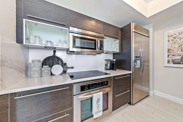 a kitchen with stainless steel appliances granite countertop a stove top oven microwave and sink