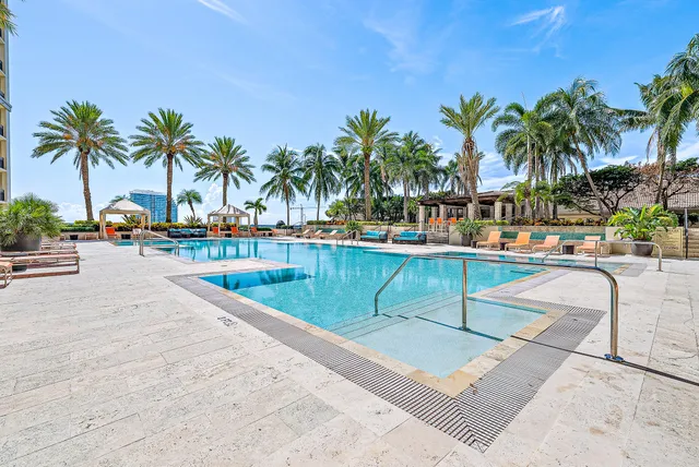 a view of swimming pool with outdoor seating and palm tree