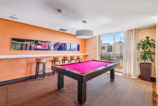 a room with pool table and windows