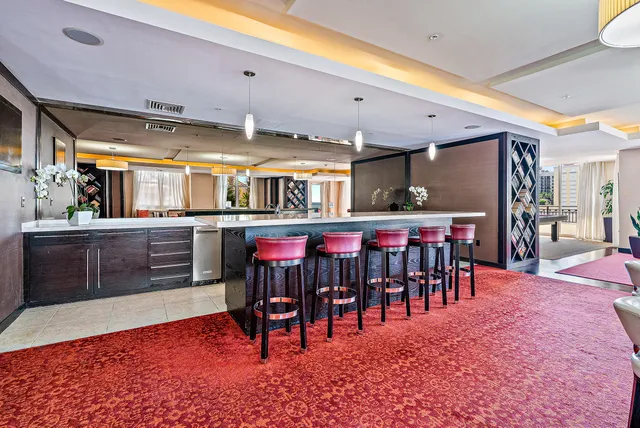 a large dining hall with stainless steel appliances granite countertop a dining table and chairs